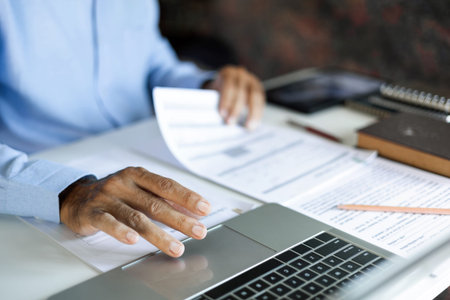 close up shot, asian businessman, legal expert, professional lawyer working with laptop reviewing document and business contract before provide legal advice to clientsの写真素材