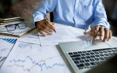 Investors working on desk with laptop checking financial report analyze investments and use data...