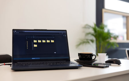 computer laptop showing blank folder on screen with coffee cup and mobile phone on desk, modern...