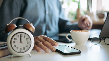 close up shot, businessman using mobile working on desk with laptop before breaking lunch