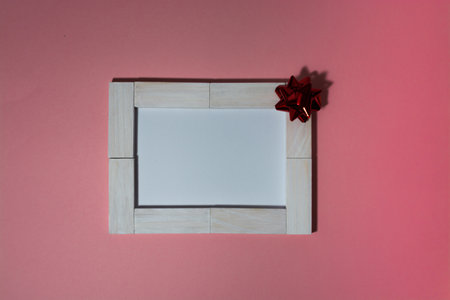 A white-block framed card decorated with a bow on a pink backgroundの写真素材
