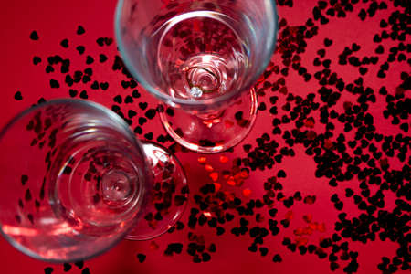 Champagne glasses,ring and red confetti.の写真素材