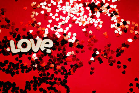 The word love with confetti on a red backgroundの写真素材