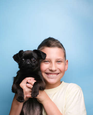 Boy smile with pet black dog puppy. Friends and happy conceptの写真素材