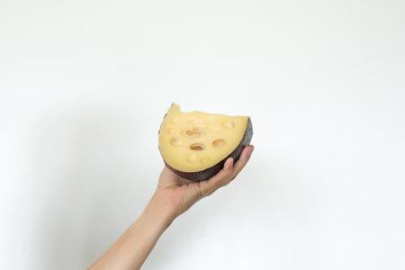 closeup of hand holding a piece of elemental cheese.の写真素材