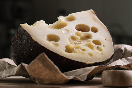 Emmental cheese triangle, Swiss cheese, on wooden board whith knife and craft bag. high resolution...