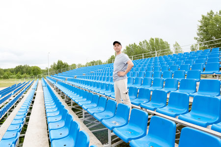 A men in black cap stand in stadium background and looking forward. Morning physical jerks outdoor...