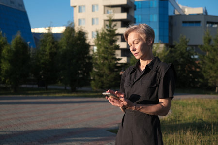 Business Woman With Phone Near Office. Portrait Of Beautiful senior Female In Fashion Office Clothes...