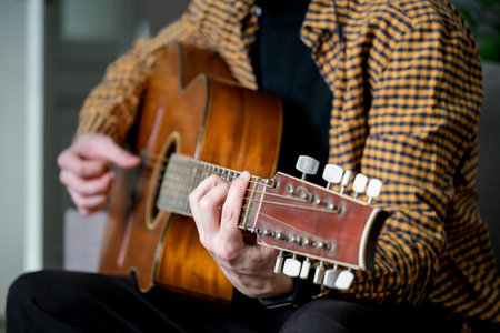 Man playing acoustic guitar. Close-up of male hands playing acoustic guitar