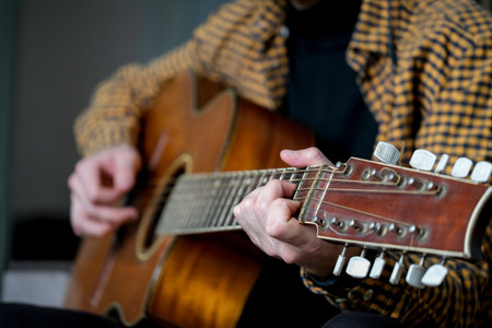 Guitarist playing an acoustic guitar. Close-up of a man playing an acoustic guitar.