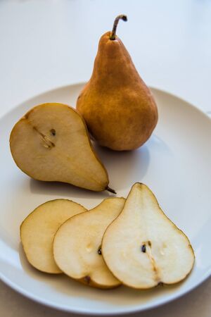 Cut pears on a white plateの写真素材