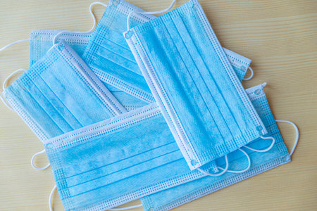 Blue surgical masks on wooden surface