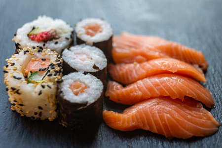 Sushi, uramaki, rolls and sashimi on a slate tray.の写真素材