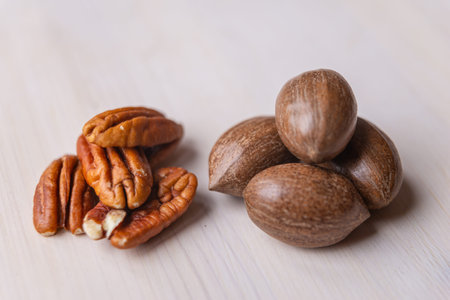 Walnuts, and Pecan walnut kernel, on white wooden surface