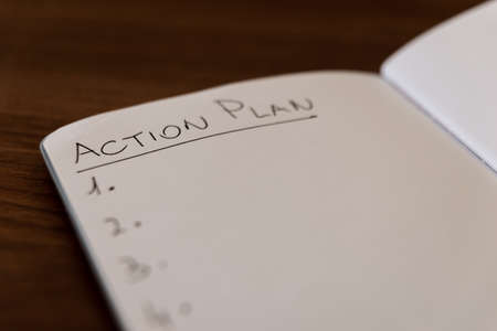 Notebook page marked 'Action plan' in black ink on white paper, and numbered list.の写真素材