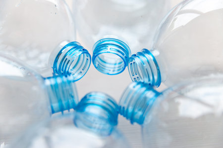 Transparent plastic bottles, on a clear surface. Transparent bottle neck. Recycling and disposal of...