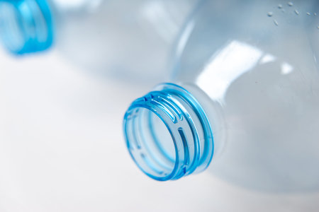 Transparent plastic bottles, on a clear surface. Transparent bottle neck. Recycling and disposal of...