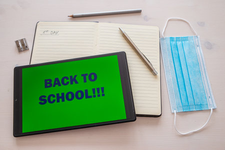 Notebook, pen, pencil, template, tablet with "back to school" text on the screen. Beginning of the school year and distancing.の写真素材