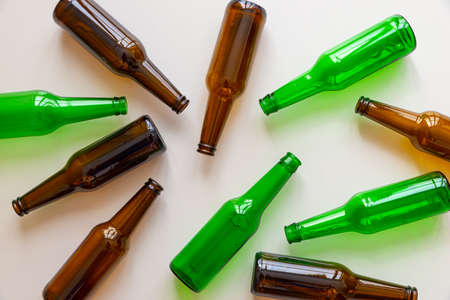Empty beer or beverage bottles on white surface. Reuse and recycling of glass. Waste.の写真素材