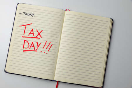 Page of diary or agenda, with the text "today ... tax day", and money next to it. Deadlines and tax obligations. Tax increase.の写真素材