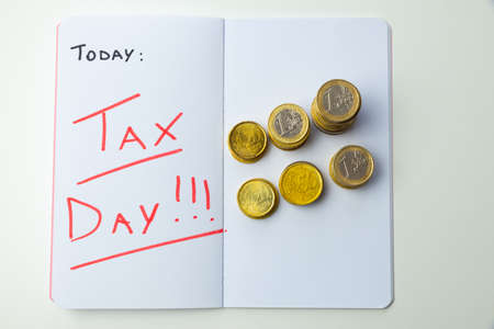 Page of diary or agenda, with the text "today ... tax day", and money next to it. Deadlines and tax obligations. Tax increase.の写真素材
