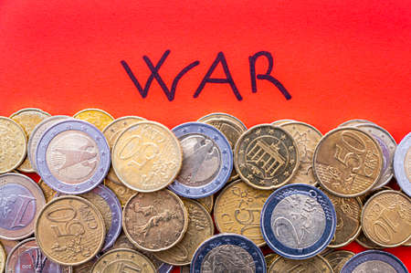 Word "war", written in black on a red surface, and coins next to it. Retaliation and economic sanctions against war. Economic sanctions and trade wars.の写真素材