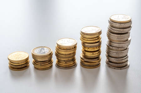 Stacks of coins of increasing height, rising prices and increasing wealth.の写真素材