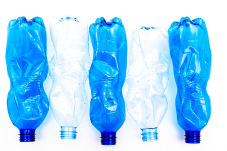 Plastic bottles, blue and transparent, crushed. Waste and plastic pollution, plastic recycling.