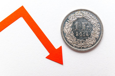 1 Swiss Franc coin, next to descending line. Valuation of the Swiss Franc and falling exchange rate.の写真素材