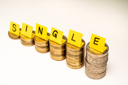 Stacks of coins with text Single. Economic conditions of single people, higher expenses of single...