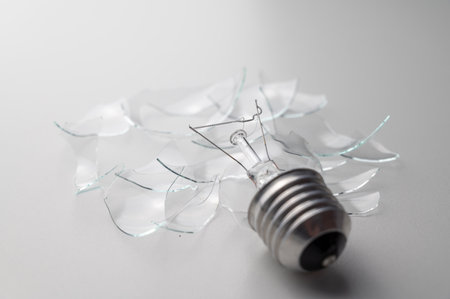 Broken lightbulb on white background, closeup of photoの写真素材