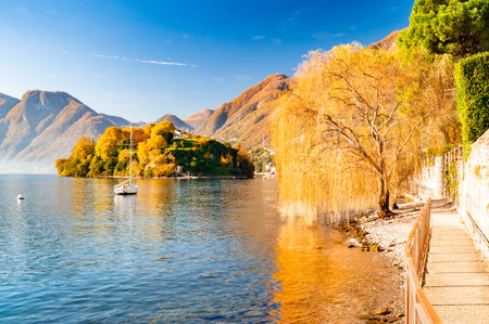 Comacina Island, photographed in autumn, with trees, boats and piers around.の写真素材
