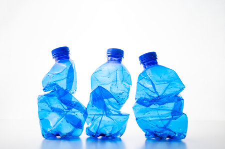 Plastic bottles, blue and transparent, crushed. Waste and plastic pollution, plastic recycling.の写真素材