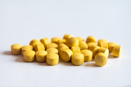 Medical tablets, placed next to each other on a white surface. Therapies, medicines and supplements.の写真素材