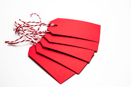 Red Christmas card, with a string, on a white surface. Christmas and Christmas greetings.