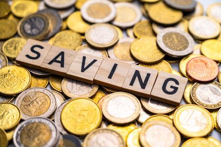 Savings word on wooden block with coins background. Financial concept.の写真素材