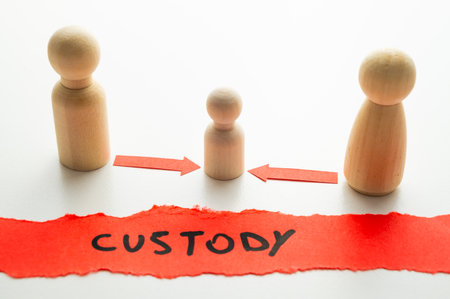 Concept of divorce and child custody dispute, expressed with wooden pieces, arrows, and the word "custody."の写真素材