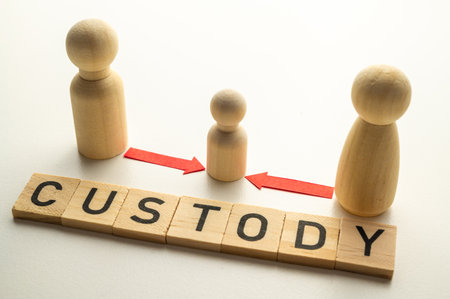 Concept of divorce and child custody dispute, expressed with wooden pieces, arrows, and the word "custody."の写真素材