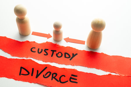 Concept of divorce and child custody dispute, expressed with wooden pieces, arrows, and the word "divorce" and "custody."の写真素材