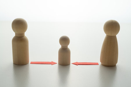 Concept of divorce and child custody dispute, expressed with wooden pieces, red arrows.の写真素材