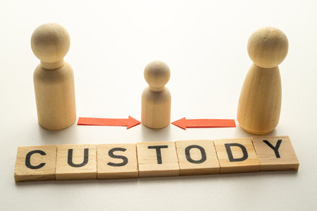 Concept of divorce and child custody dispute, expressed with wooden pieces, arrows, and the word "custody."の写真素材
