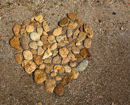 Heart from stones on sand seacoastの写真素材