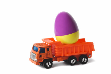 Easter egg delivery to home by orange toy truck. Concept for Easter purchase. Egg different color...