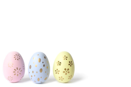 Three pastel coloring eggs in cardboard box on isolated white background. selective focus. high...