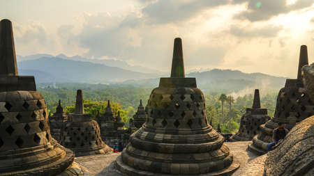 Glorious sunset at Borobudur Temple in East Java, Indonesia. Blue and orange sky over the hills, green jungles and stupa, travel destination, UNESCO World Heritage Siteのeditorial素材