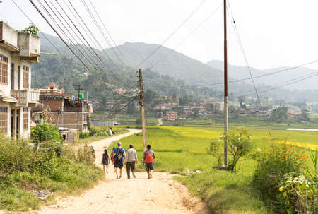 Namo Buddha, Nepal - September 20, 2020: A group of tourists walking in the countryside road in a village of Nepal, paddy fields in Asia, hiking tourのeditorial素材