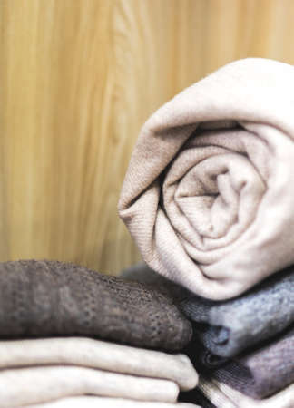pile of clothes, rolled beige cashmere blanket, Knitting cashmere wool yarn, closeup beige blanket, home decor, closeup rolled beige cashmere woollen blanket, soft selective focus, copy paste conceptの写真素材