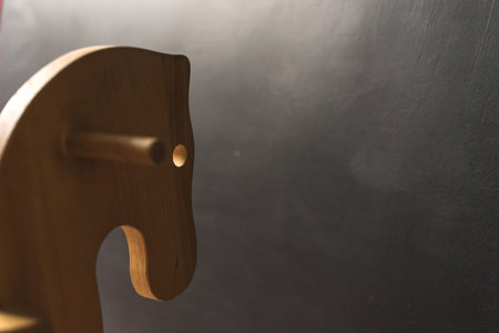 handmade wooden horse toy for children at the dark wall, copy paste concept, childhoodの写真素材