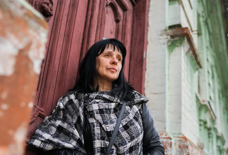 A beautiful adult woman at the front of the door, travelling in Europe, old rustic door in the...