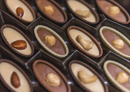 close up of chocolate candies, Chocolate candies in a box, hazelnut almond and cashew nuts in choco...